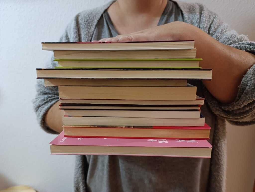 a person holding a stack of books