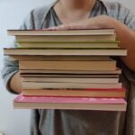 a person holding a stack of books