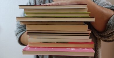 a person holding a stack of books