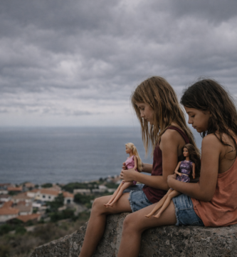 Niñas con muñecas en la costa.